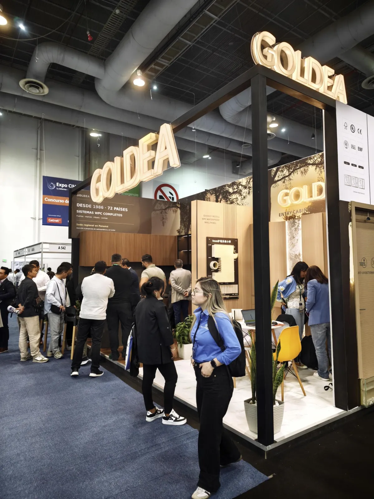 Visitors walking past the Goldea booth at Centro Banamex
